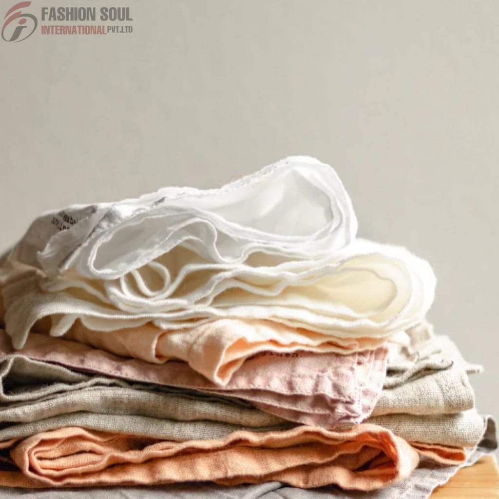 A neatly folded stack of various clothing items, including underwear and fabric pieces, placed on a flat surface.