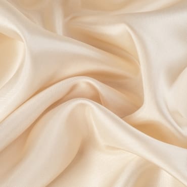 Smooth, shiny silk chiffon fabric in a soft cream color with gentle folds.