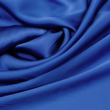 Vibrant blue stretch chiffon fabric with smooth, flowing folds, showcasing its elasticity.
