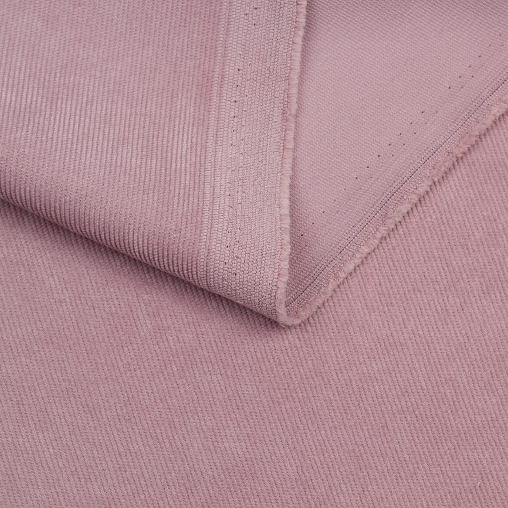 Close-up of soft, light pink corduroy fabric with a neatly folded edge, highlighting the textured ridges.