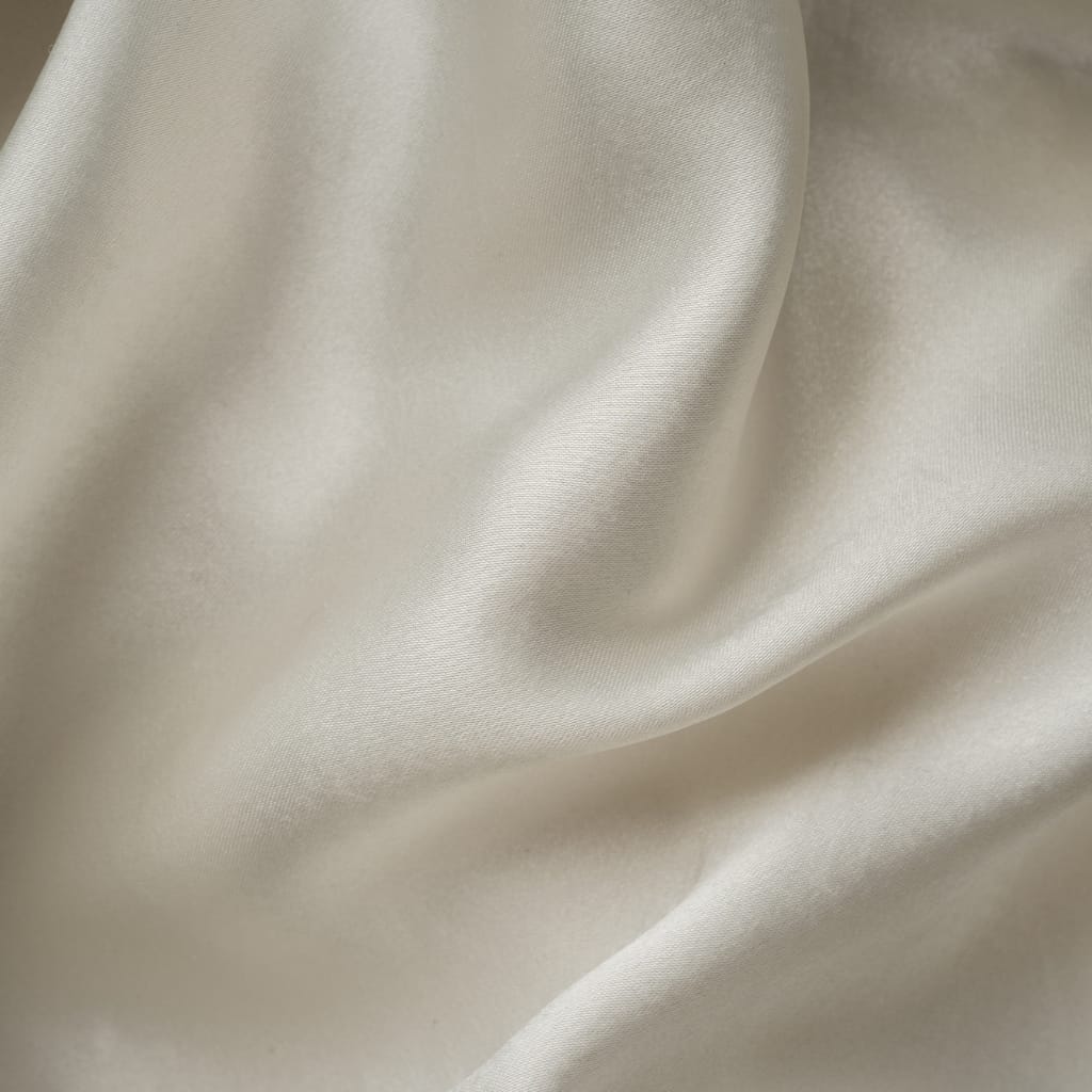 Close-up image of smooth, creamy-colored Tencel fabric with gentle folds.