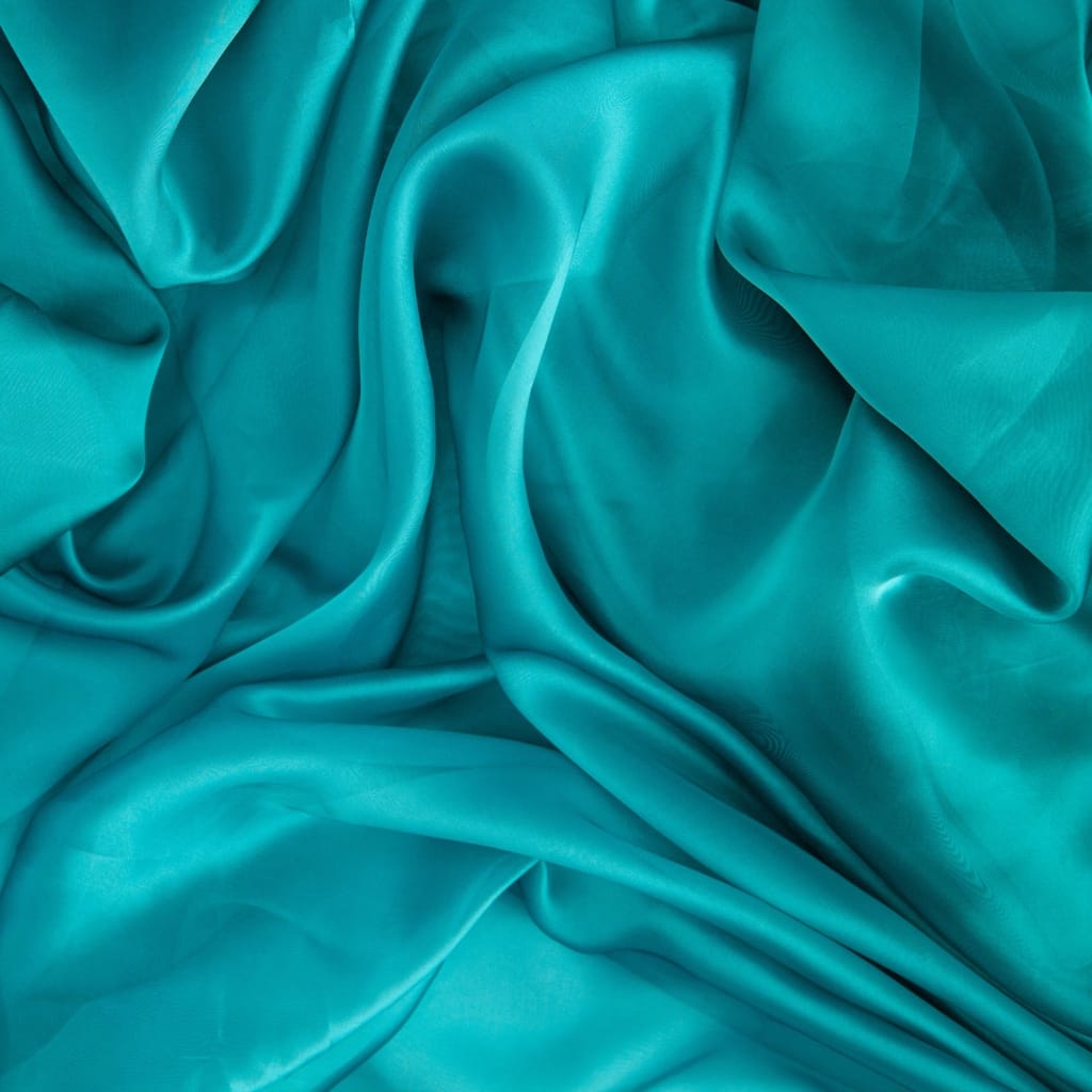 Close-up image of smooth, flowing, turquoise nylon fabric with gentle folds and a shiny, silky surface.
