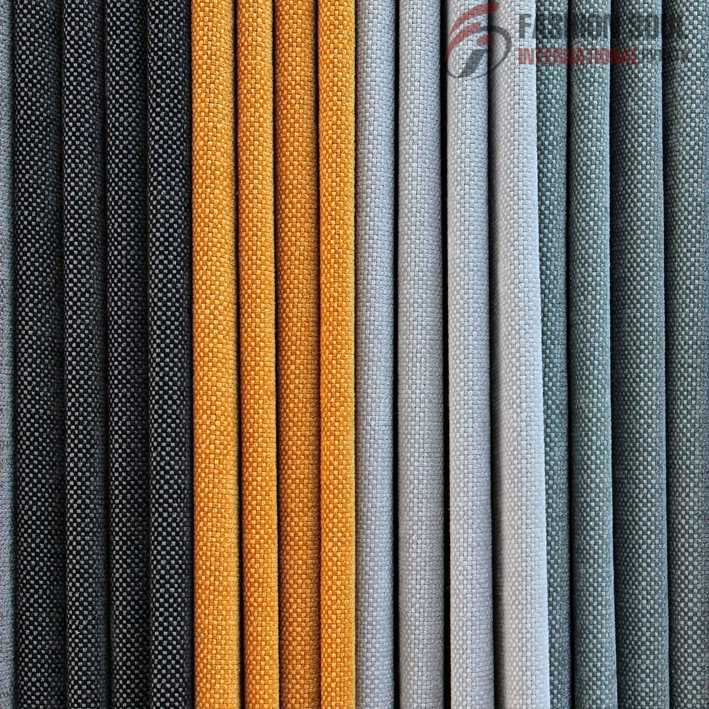 A neatly arranged row of fabric rolls in various colors, including black, orange, light gray, white, and shades of teal, all with a textured weave pattern.