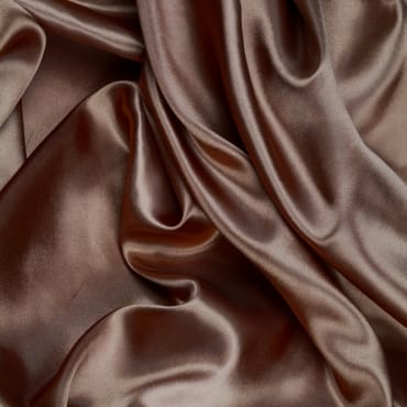 Close-up image of rich brown velvet spandex fabric with smooth, shiny, and luxurious folds.