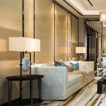 Elegant living room with a plush velvet sofa, modern table lamps, and a stylish wall with vertical lighting accents, creating a sophisticated ambiance.
