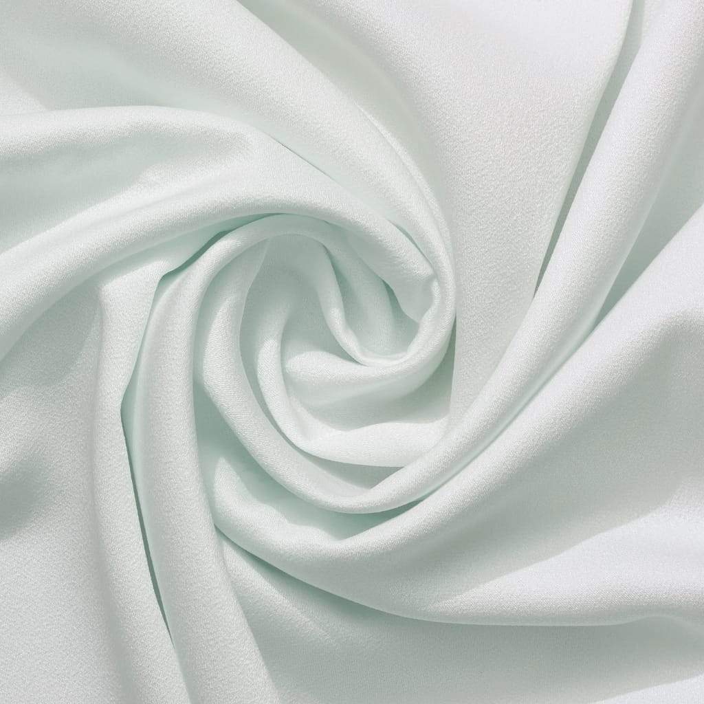: A close-up image of smooth, white Egyptian cotton fabric with a soft, luxurious appearance, gently folded into a swirl.