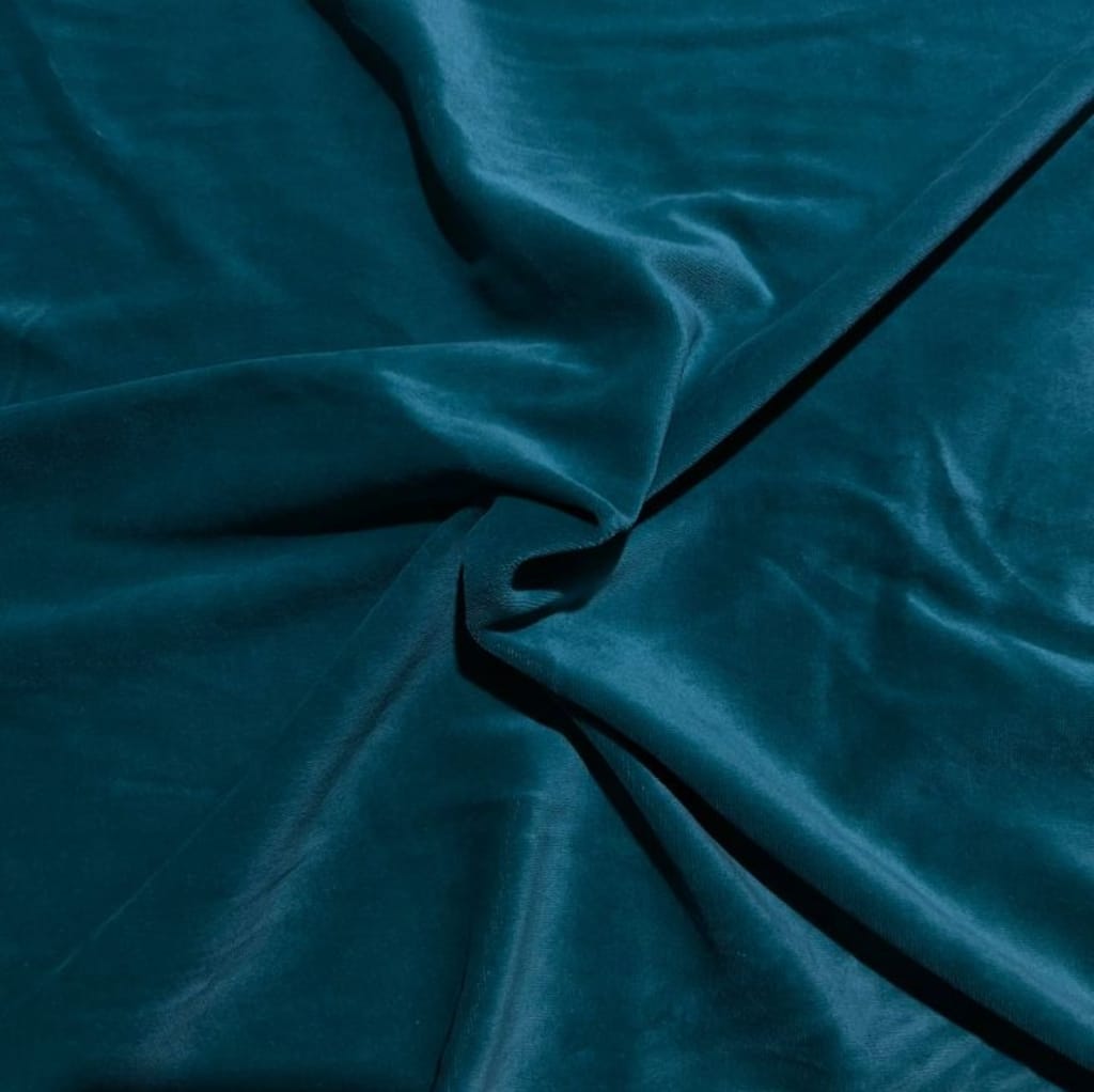 A close-up image of teal velvet or velour fabric draped with soft folds, showcasing its smooth, plush texture.
