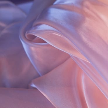 Close-up of soft, pastel-colored chiffon fabric with gentle folds and sheen.