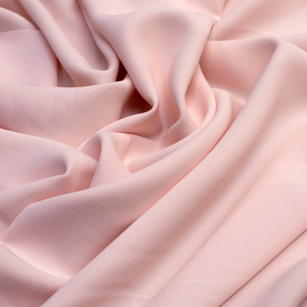 Close-up photo of soft, light pink acetate fabric with gentle folds and smooth texture.