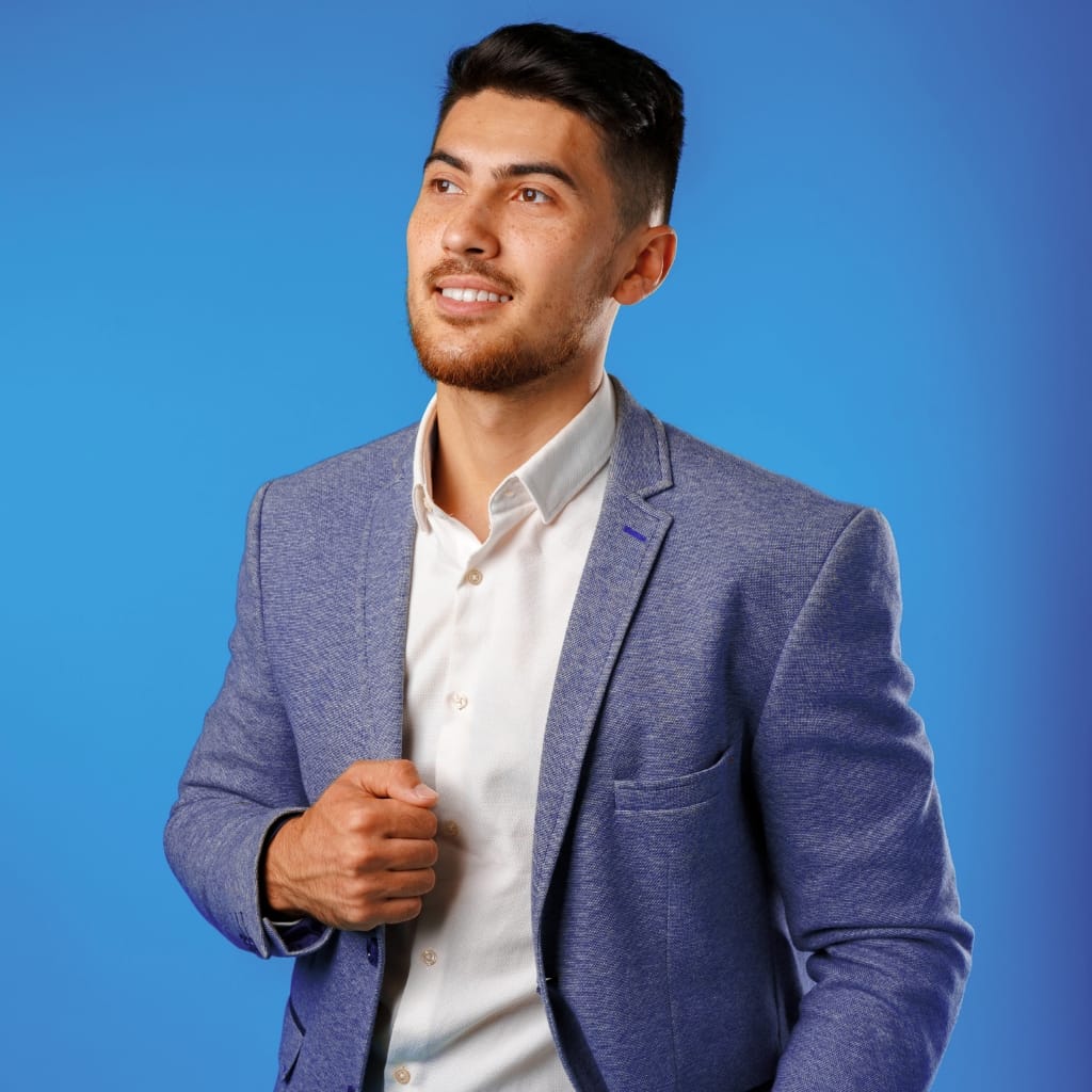 Man wearing a blue sports jacket paired with gray trousers and brown loafers