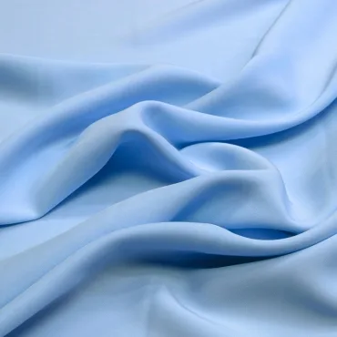 Close-up image of light blue rayon spandex fabric with soft, flowing folds, highlighting its smooth and slightly shiny surface. " rayon spandex fabric"