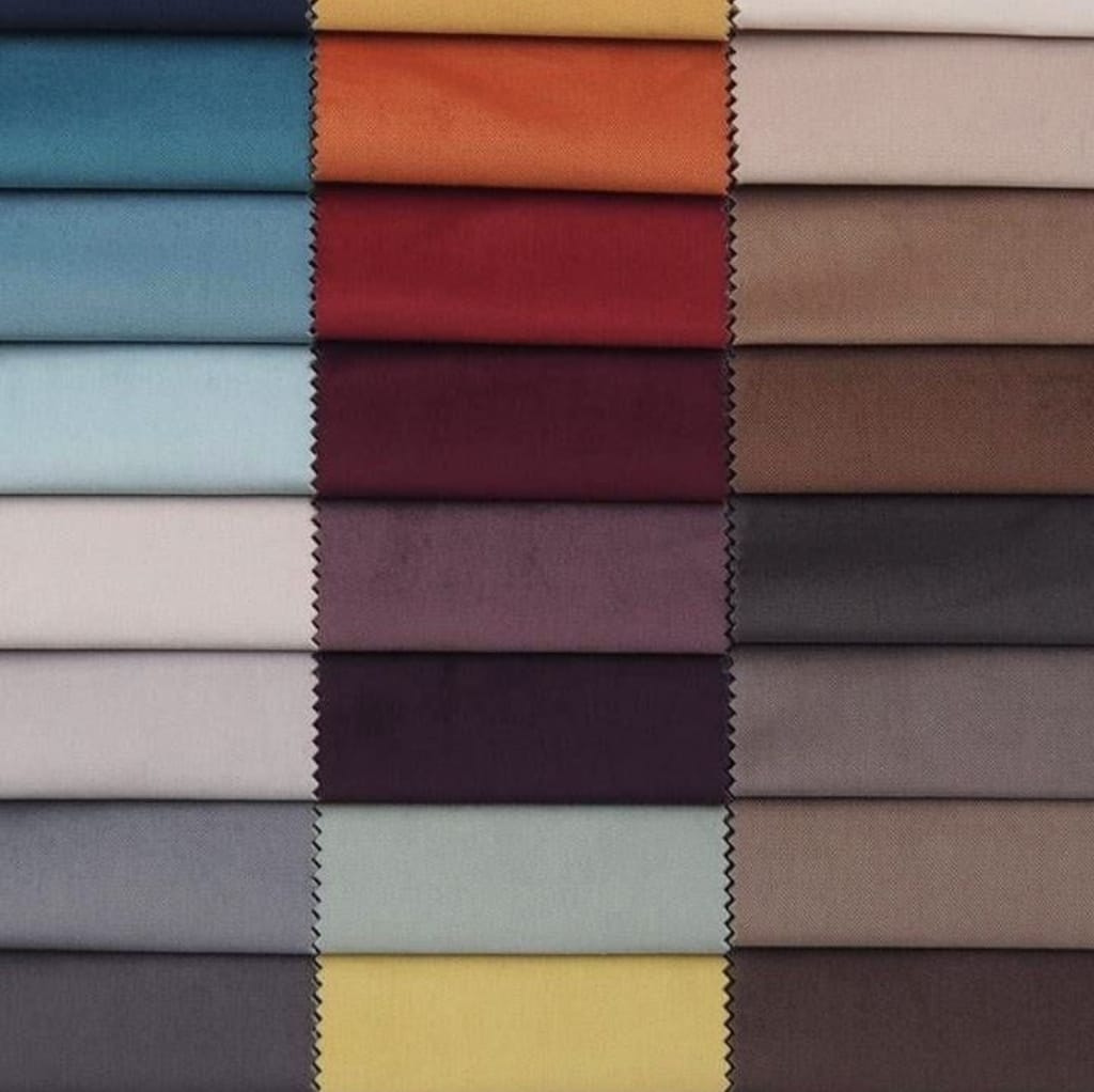 A neatly arranged display of fabric swatches featuring a variety of colors, textures, and finishes, including velour among other textiles.