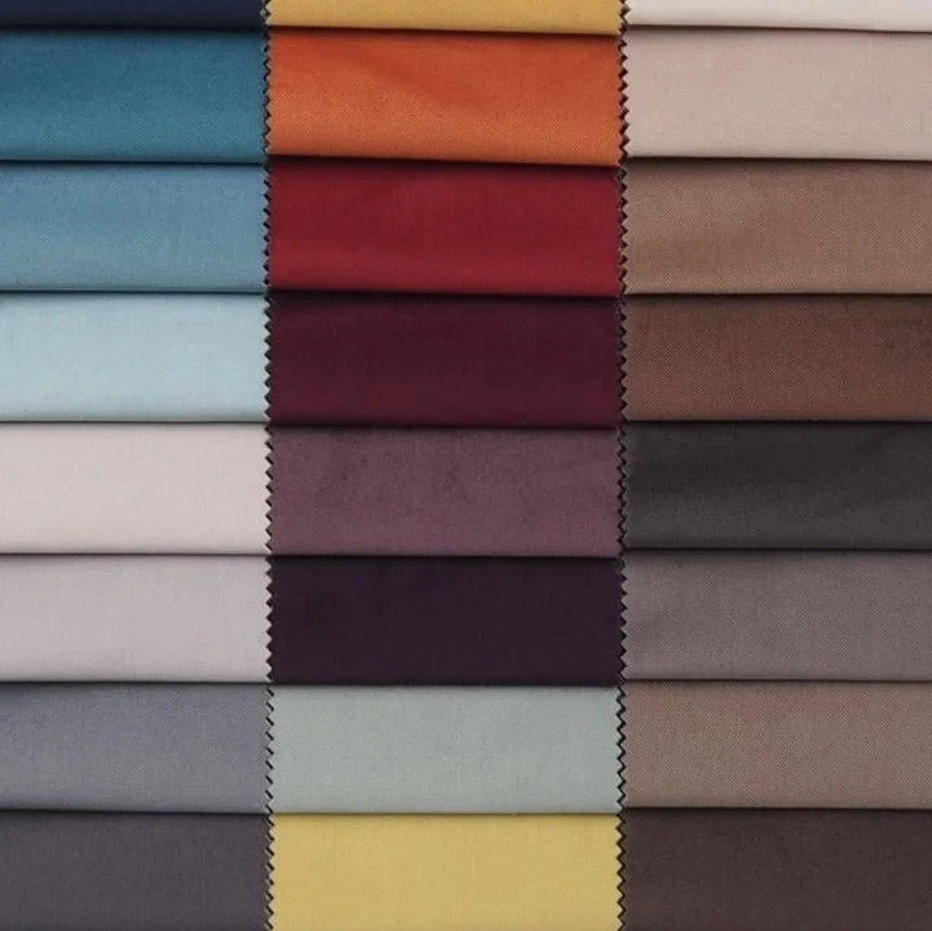 A neatly arranged display of fabric swatches featuring a variety of colors, textures, and finishes, including velour among other textiles.
