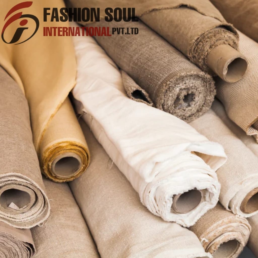 Several rolls of neutral-toned fabric and upholstery material are displayed, with a logo and text "FASHION SOUL INTERNATIONAL PVT. LTD" in the top left corner.