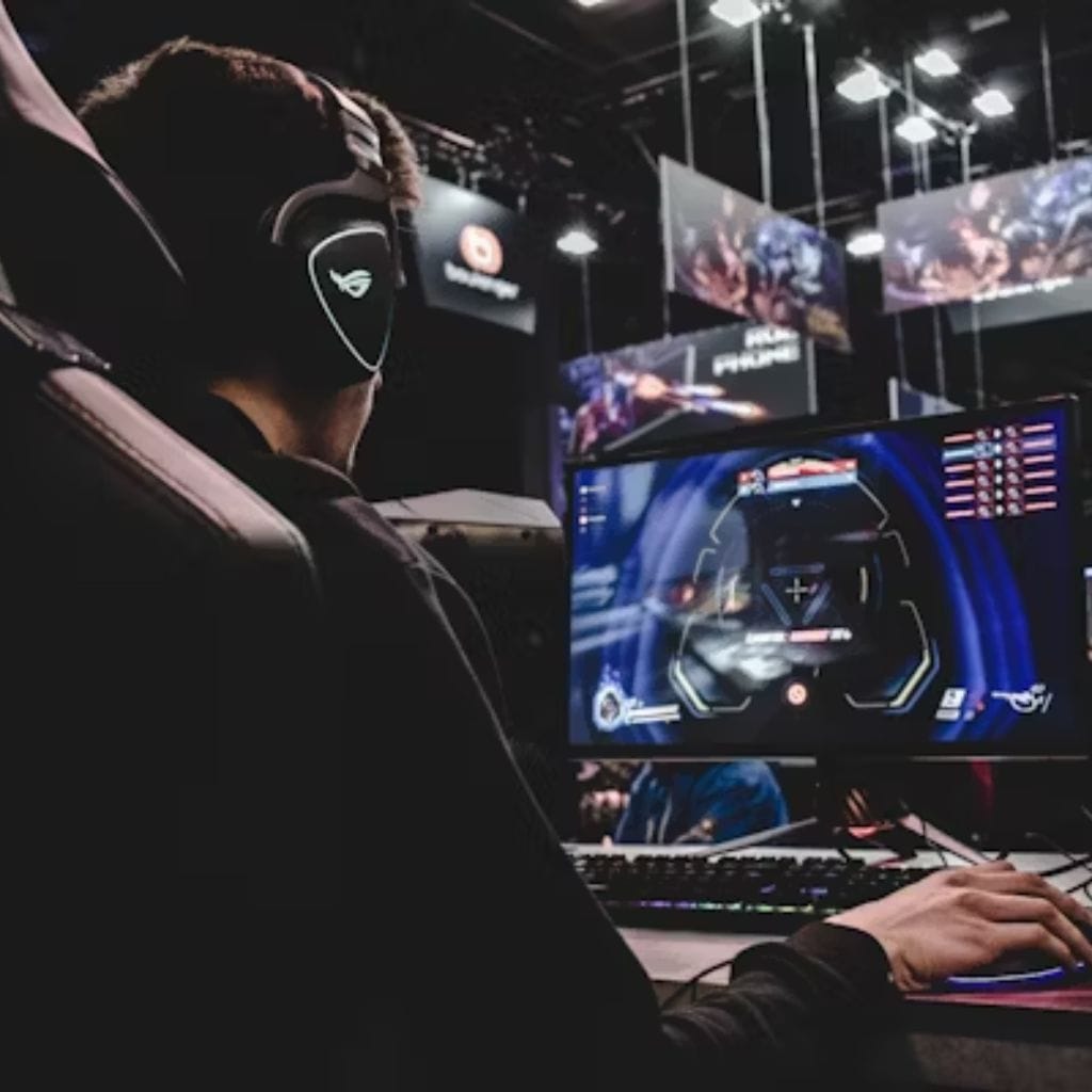 Gamer playing a first-person shooter at an esports event — write for us gaming.