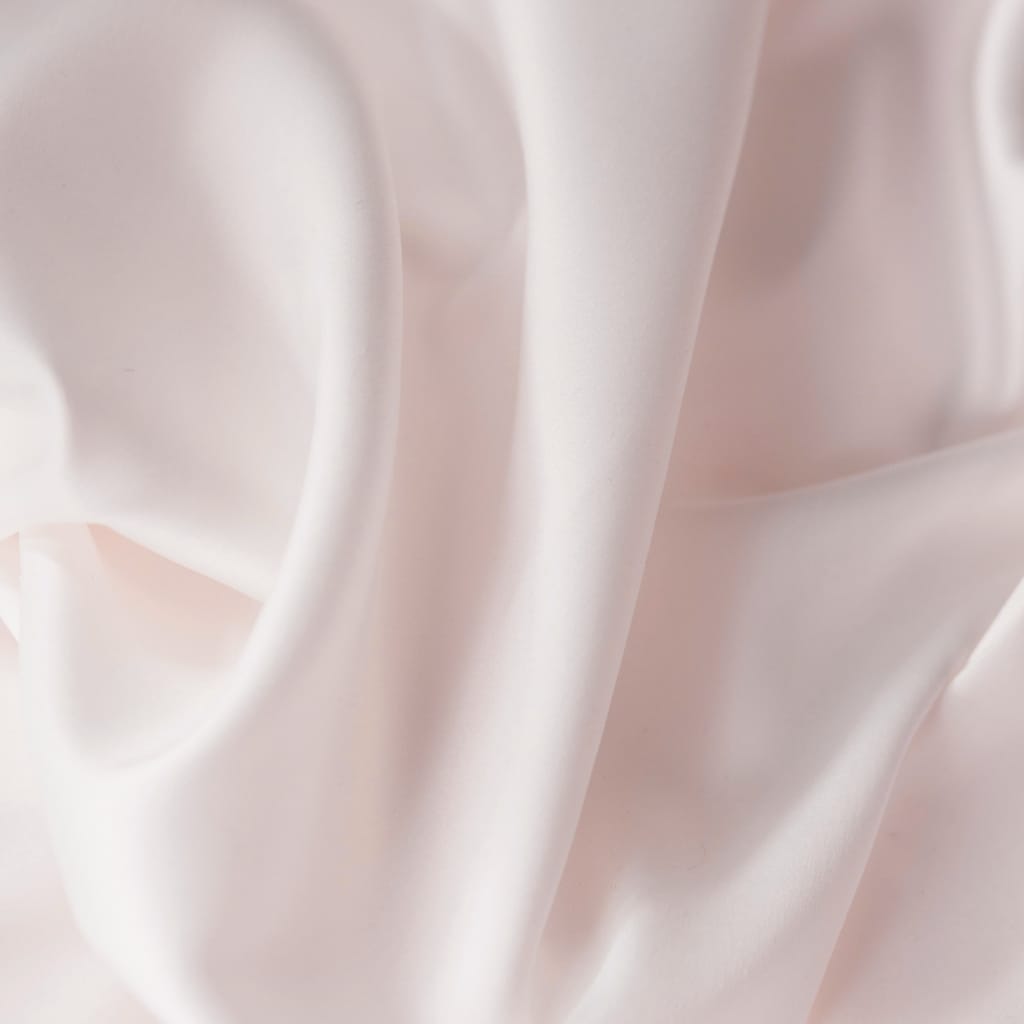 Close-up image of smooth, creamy, and shiny fabric with gentle folds, showcasing its soft and silky texture.