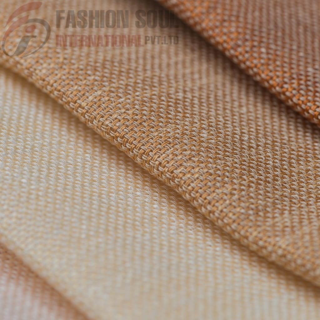 Close-up view of three folded pieces of woven fabric in shades of beige and light orange, showcasing their textured surface and detailed weave pattern.