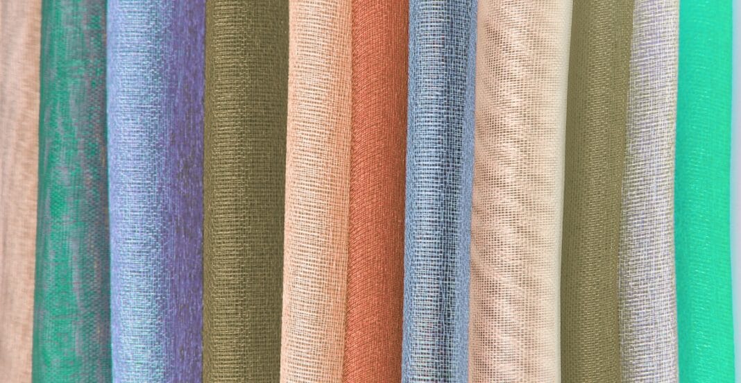 Close-up image of multiple rolls of nylon organza fabric in various colors, showcasing the sheer and lightweight texture.