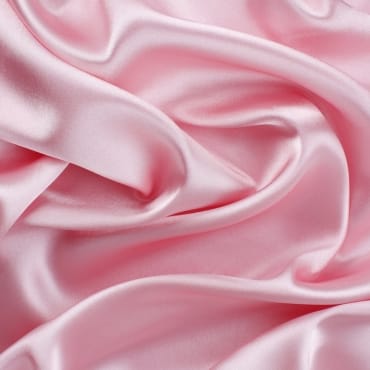 Close-up of soft pink silk velvet fabric with a smooth, lustrous, and luxurious surface.