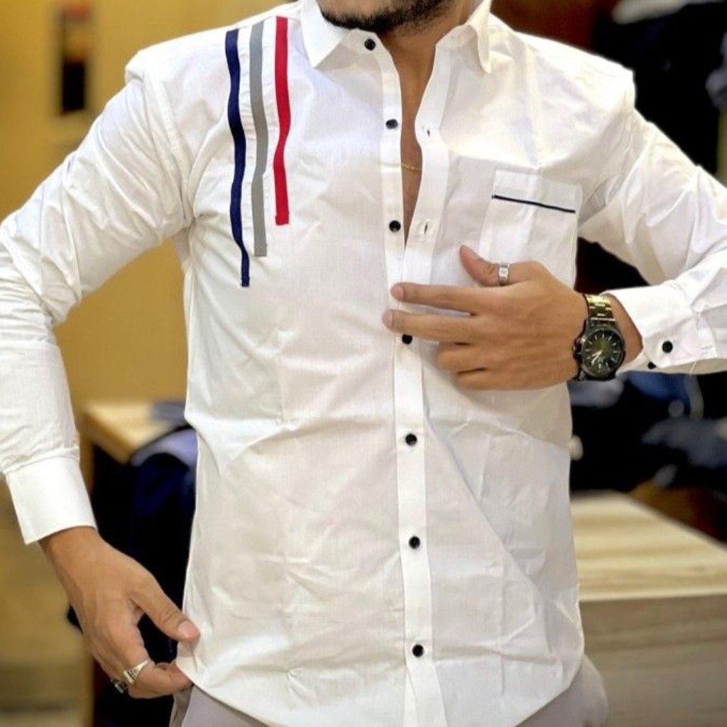 A close-up of a man wearing a stylish white button-down shirt with colorful stripe details on the shoulder and a pocket on the left side.