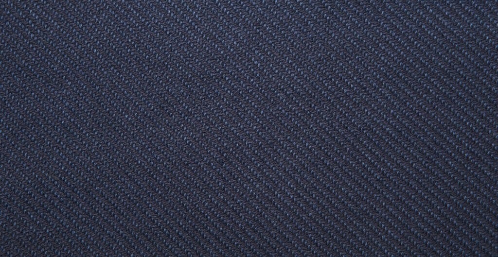 Close-up image of dark blue twill weave cotton fabric, showing the diagonal rib pattern.