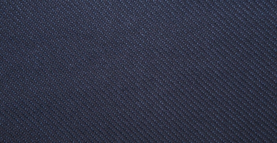 Close-up image of dark blue twill weave cotton fabric, showing the diagonal rib pattern.