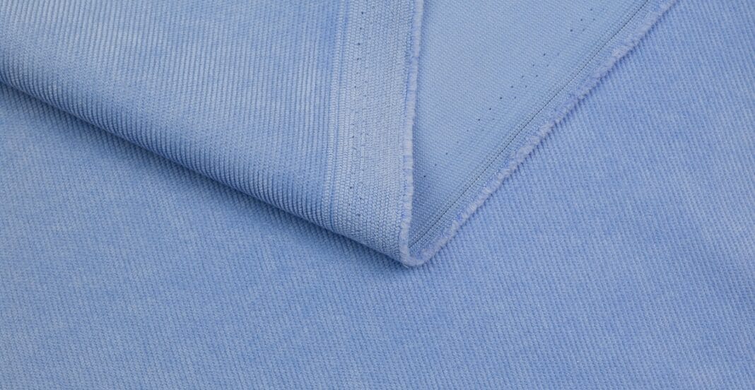 Close-up image of light blue corduroy fabric with distinct ridges and texture.
