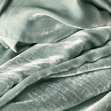 Close-up of soft, light gray velvet fabric with a smooth, plush surface and subtle sheen.
