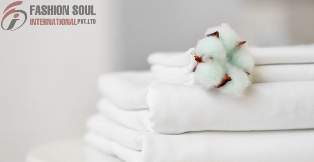 Packaged white fabric with a cotton flower on top, featuring the logo and text "Fashion Soul International Pvt. Ltd." in the upper left corner.