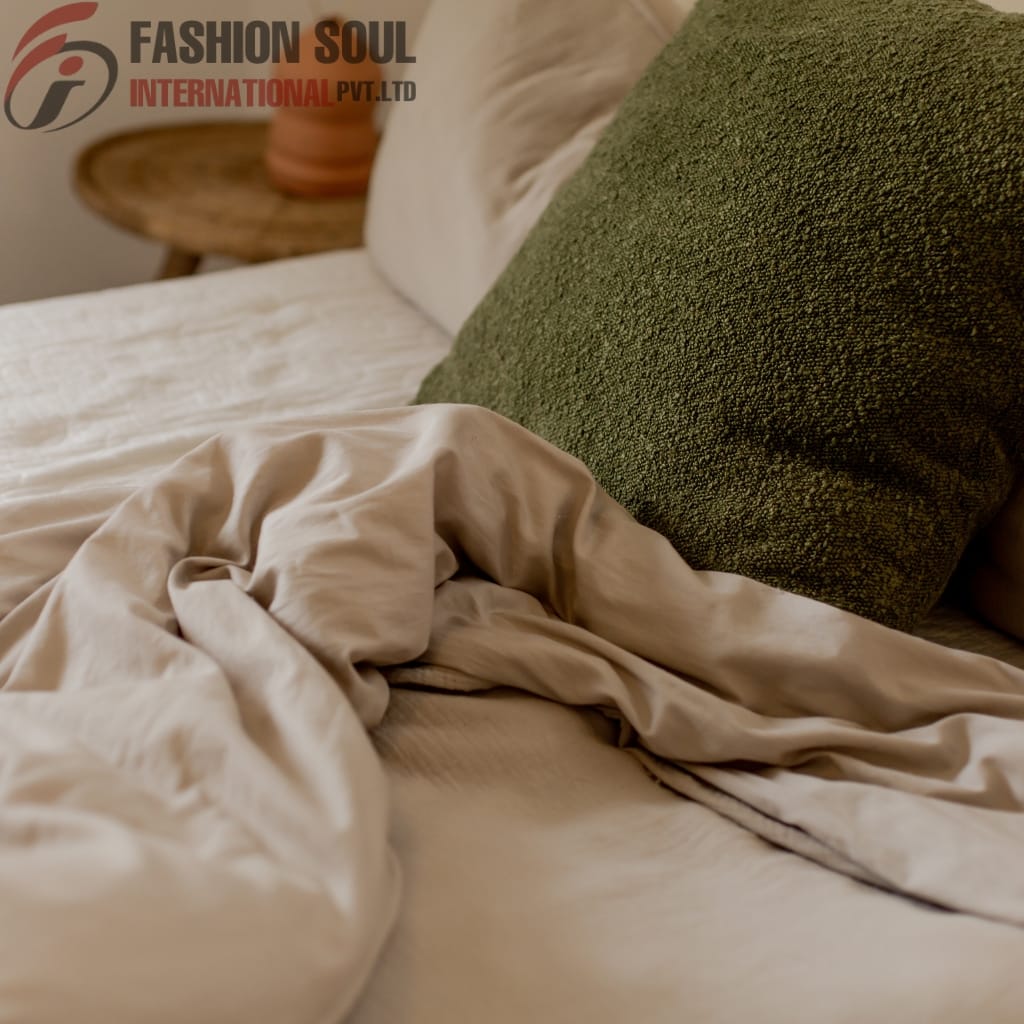 Neutral-toned bed sheet bundle with green textured cushion on a cozy bed setup.