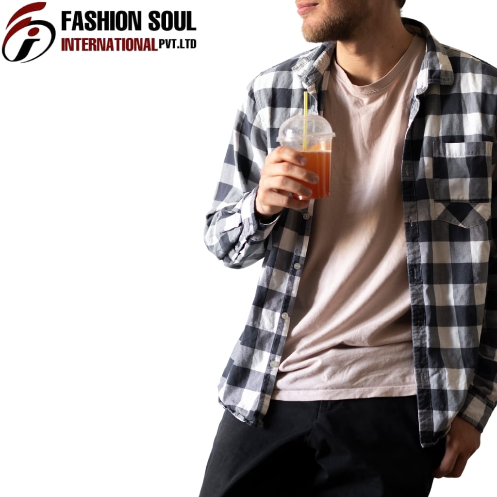  A man dressed in a casual checkered shirt over a beige T-shirt holds a plastic cup with a straw, which contains an orange-colored beverage. Only the lower part of his face and his upper body are visible, with his leisure stance and relaxed outfit.