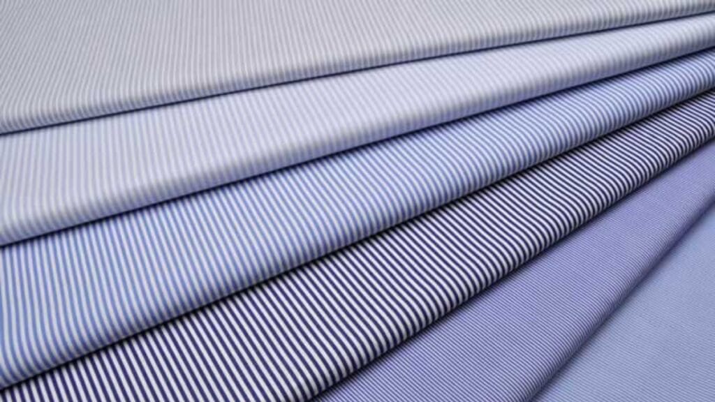 A close-up of cotton poplin fabric showing its tight, smooth weave and subtle sheen.