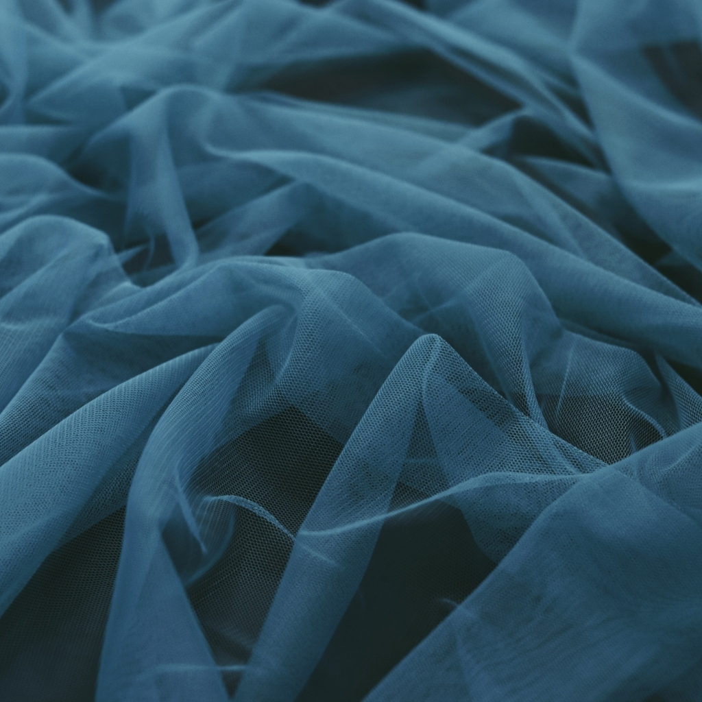 Close-up of soft, wrinkled blue tulle fabric with delicate, sheer texture.