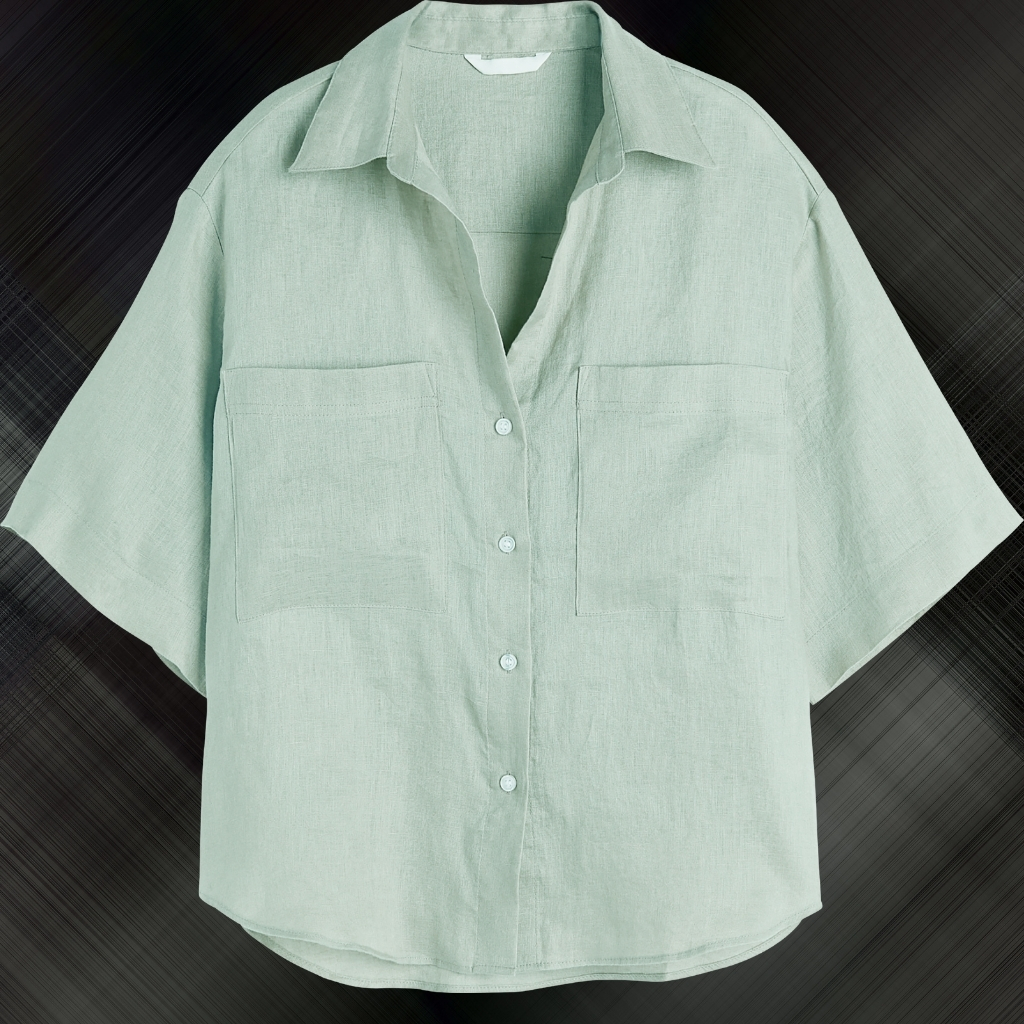 A light green short-sleeved button-up shirt with two chest pockets, displayed against a dark, blurred background.