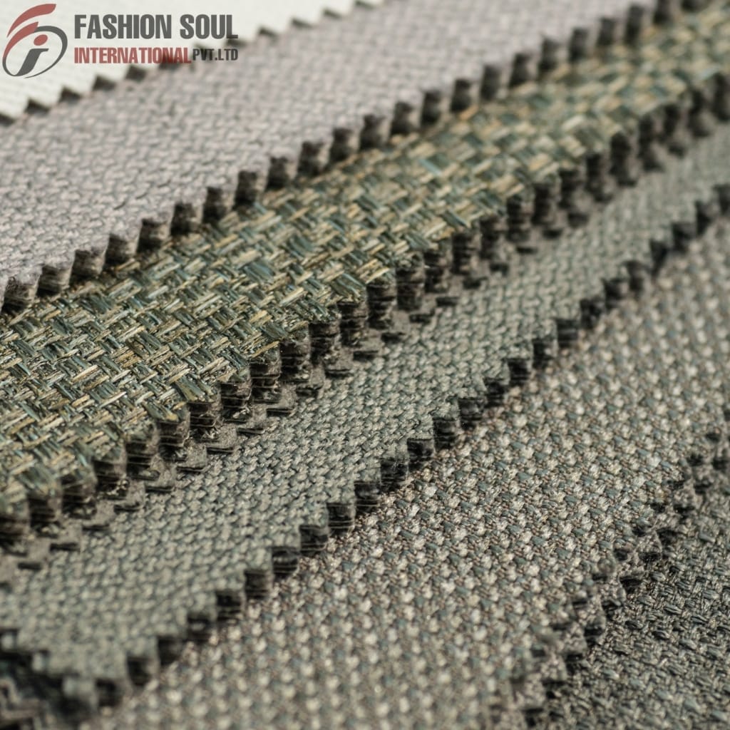 Close-up of several fabric swatches with a textured weave, showcasing different shades of grey and green, with the "Fashion Soul International Pvt. Ltd" logo in the top left corner.