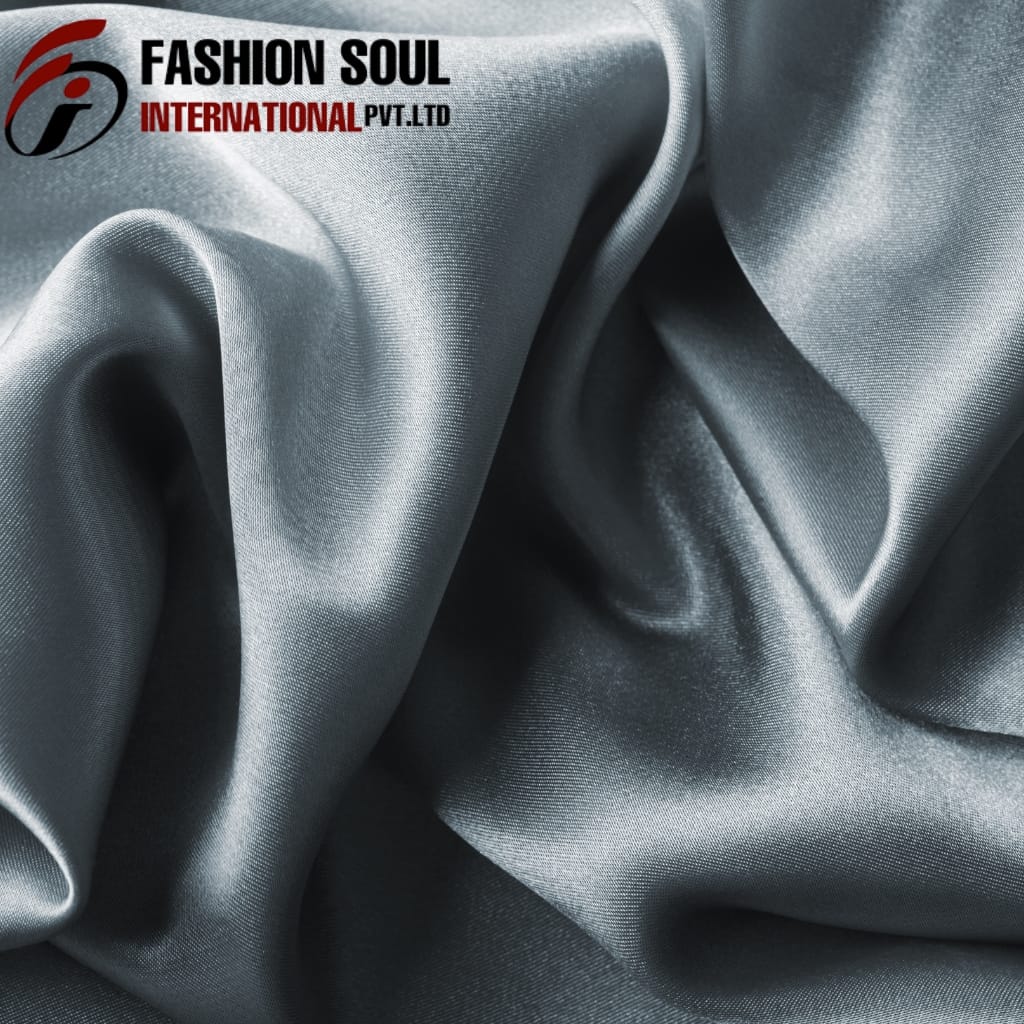 Close-up of smooth, shiny silver-gray satin fabric with elegant folds and sheen.