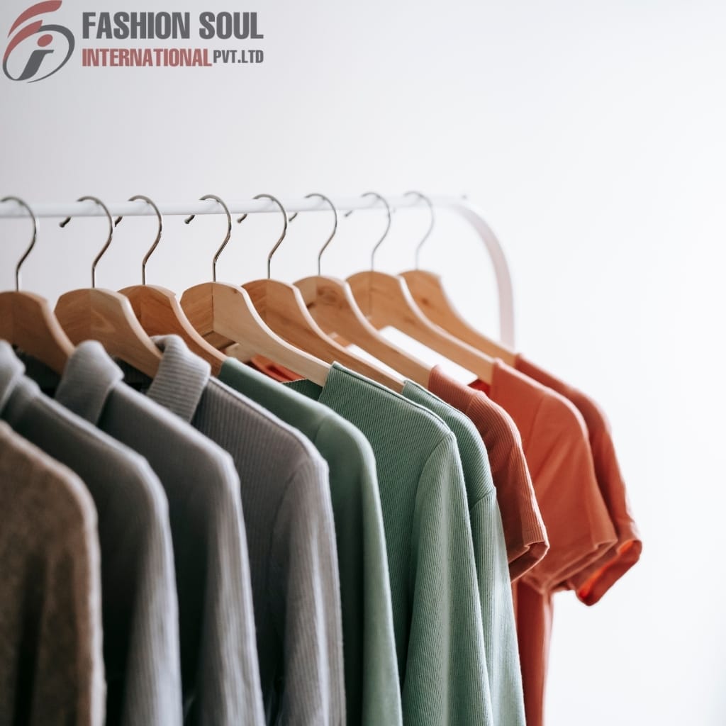 A row of colorful shirts hanging on wooden hangers on a white clothing rack, with a plain white background and the "Fashion Soul International" logo in the top left corner.