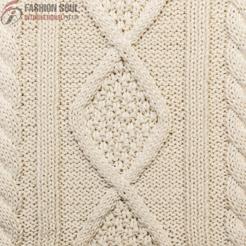 A close-up image of a knitted fabric pattern featuring a diamond-shaped cable design with braided edges, made of thick cream-colored yarn.