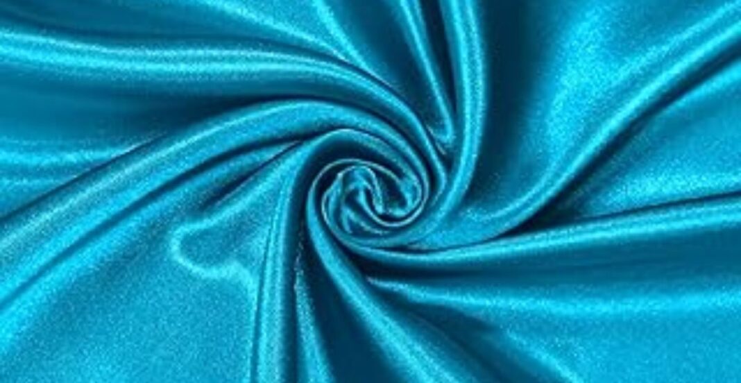 Close-up of vibrant turquoise satin fabric with a smooth, glossy texture, arranged in soft, swirling folds.