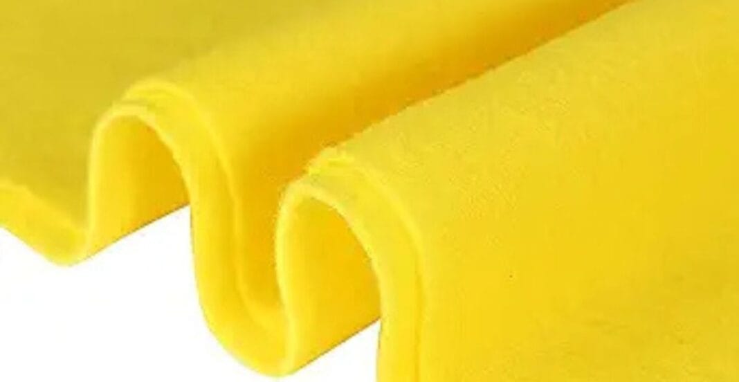 Close-up of folded yellow fabric with a smooth texture.