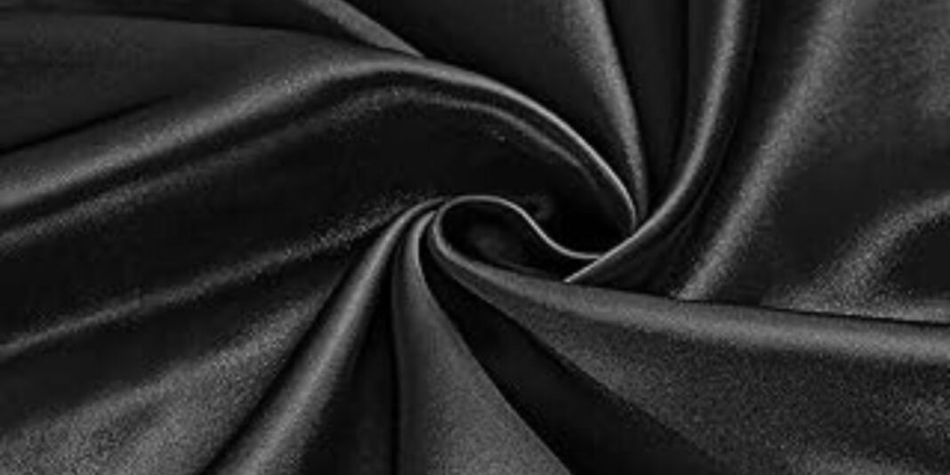 Black satin fabric showcasing its luxurious sheen and fluid drape.