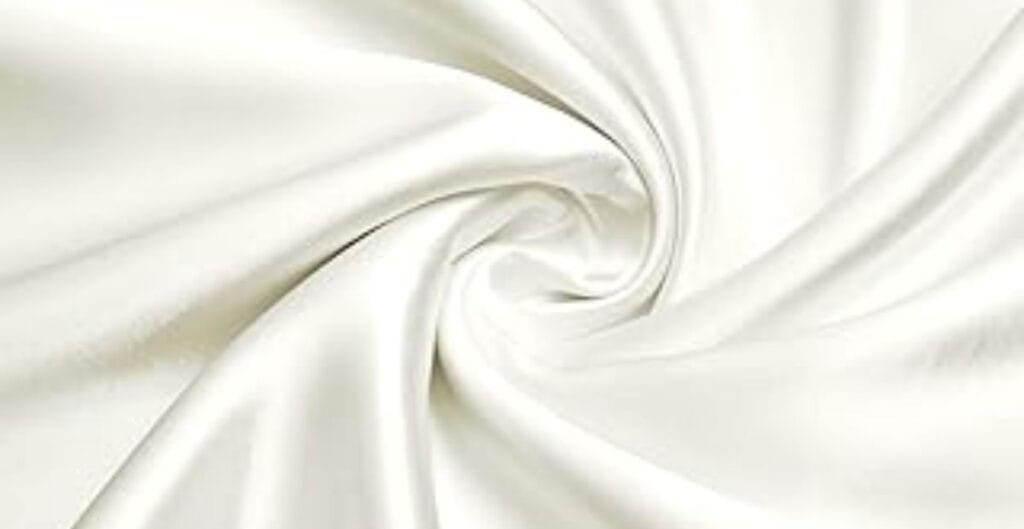 Close-up of smooth, white satin fabric twisted into a gentle spiral pattern.