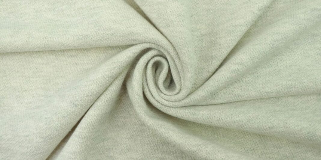 Light grey heathered knit fabric twisted into a spiral.