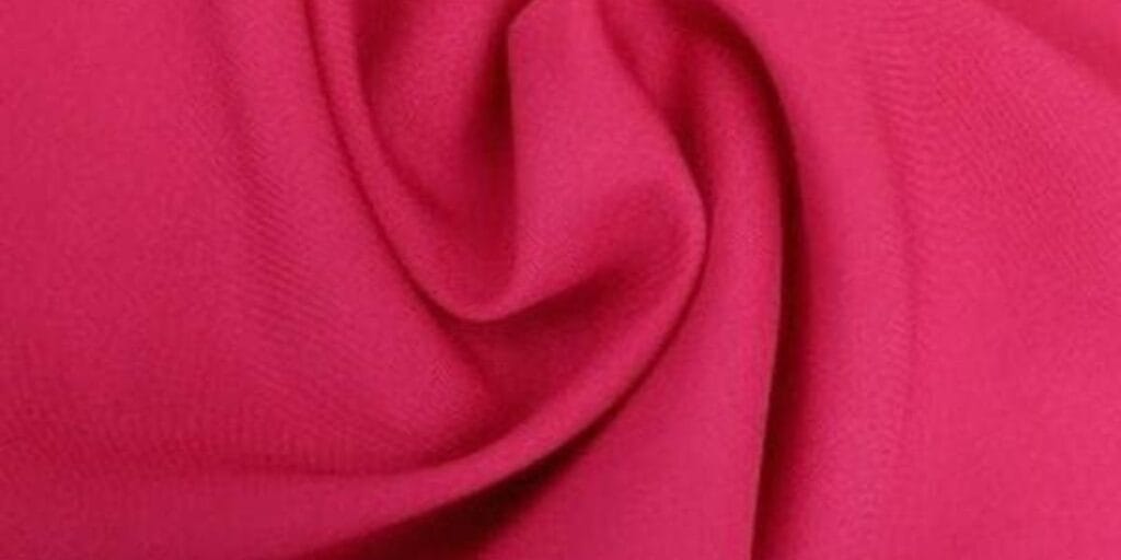 Close-up of a bright pink fabric with soft folds.