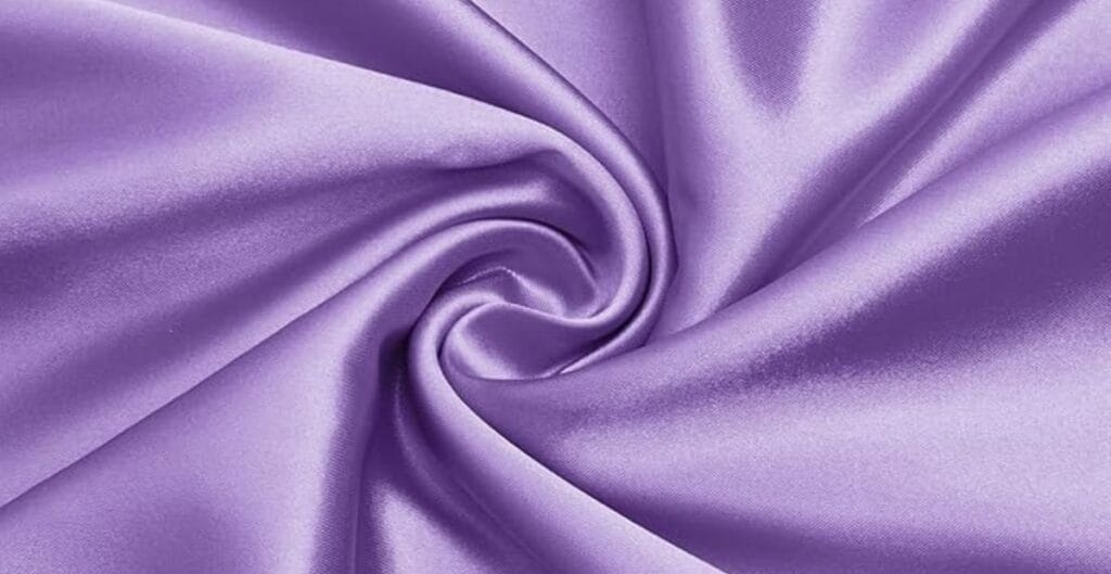 Close-up of a swirl of shiny lavender satin fabric.