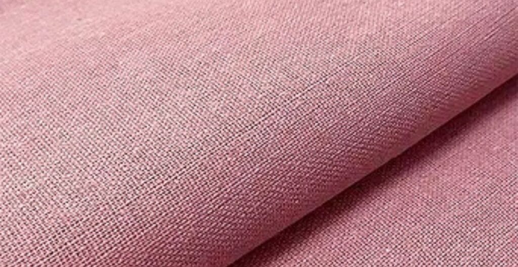 Close-up of pink textured fabric with a tightly woven pattern.