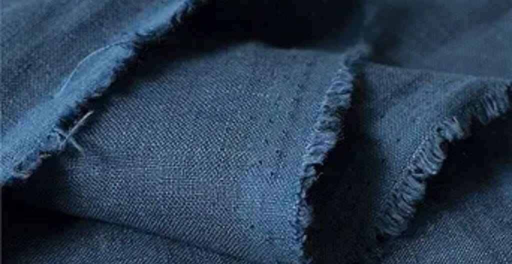 Close-up of blue linen fabric with frayed edges