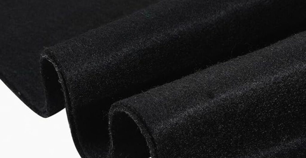 Close-up of folded black velvet fabric showing its soft and smooth texture.