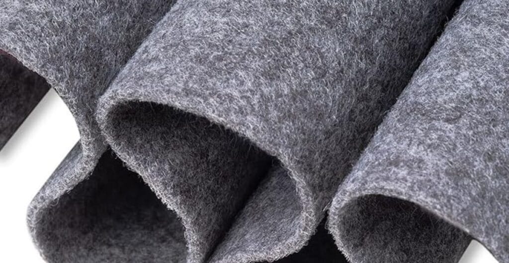 Close-up of folded grey felt fabric sheets with a soft, fibrous texture.
