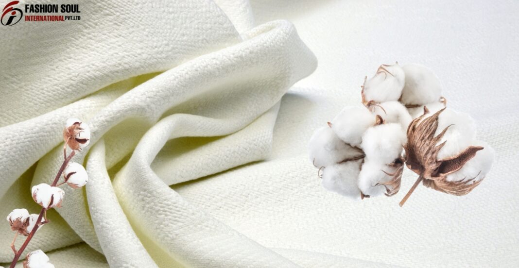 Soft white cotton fabric with raw cotton bolls, symbolizing natural textile materials.